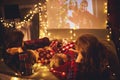 Family mother father and children watching projector, TV, movies with popcorn in   christmas evening   at home Royalty Free Stock Photo