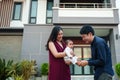 happy family, cheerful father and mother holding and playing with newborn baby while standing in front of their house Royalty Free Stock Photo