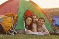 Happy family with child on camping trip relaxing inside tent. Caring parents and their daughter relaxing at campsite Royalty Free Stock Photo