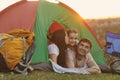 Happy family with child on camping trip relaxing inside tent. Royalty Free Stock Photo