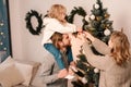Happy family with child decorate christmas tree. Little girl sitting on daddy`s shoulders hangs ball on the Christmas tree. Royalty Free Stock Photo