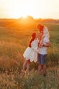 Happy family with child girl walks on meadow at sunset Royalty Free Stock Photo