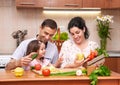 Happy family with child in home kitchen interior with fresh fruits and vegetables, pregnant woman, healthy food concept Royalty Free Stock Photo