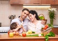 Happy family with child in home kitchen interior with fresh fruits and vegetables, pregnant woman, healthy food concept Royalty Free Stock Photo