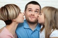 Happy family with child at home. Mother and daughter kissing daddy close up. Royalty Free Stock Photo