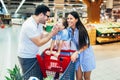 Family with child and shopping cart buying food at grocery store or supermarket Royalty Free Stock Photo