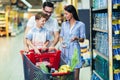 Family with child and shopping cart buying food at grocery store or supermarket Royalty Free Stock Photo