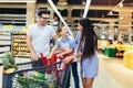 Family with child and shopping cart buying food at grocery store or supermarket Royalty Free Stock Photo