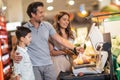 Family with child and shopping cart buying food at grocery store or supermarket Royalty Free Stock Photo