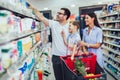 Family with child and shopping cart buying food at grocery store or supermarket Royalty Free Stock Photo