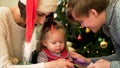 Happy family with a child spend Christmas together. Parents and daughter play at home near the Christmas tree Royalty Free Stock Photo