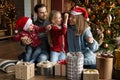 Happy family with children having fun playing near Christmas tree. Royalty Free Stock Photo