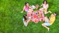 Happy family with children having picnic in park, parents with kids sitting on garden grass and eating healthy meals outdoors Royalty Free Stock Photo