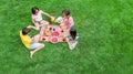 Happy family with children having picnic in park, parents with kids sitting on garden grass and eating healthy meals outdoors Royalty Free Stock Photo