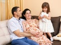 Happy family with children indoor portrait, pregnant woman and man, beautiful people portrait sit on sofa Royalty Free Stock Photo