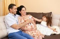 Happy family with children indoor portrait, pregnant woman and man, beautiful people portrait sit on sofa Royalty Free Stock Photo