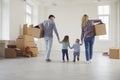 Happy family with children moving with boxes in a new apartment house. Royalty Free Stock Photo