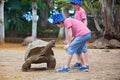 Happy family, children and parents, feeding giant tortoises in a exotic park on Mauritius island