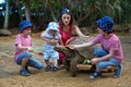 Happy family, children and parents, feeding giant tortoises in a exotic park on Mauritius island