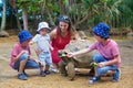 Happy family, children and parents, feeding giant tortoises in a exotic park on Mauritius island