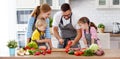 Happy family with children preparing vegetable salad
