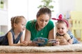 Happy family with children read a story laying on the floor in the kids room