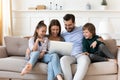Happy family with children relaxing on couch with laptop Royalty Free Stock Photo