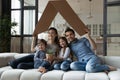 Happy family with children sitting on couch under cardboard roof