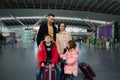 Happy family with kids stand with suitcases in the departure hall of international airport, waiting for flight check-in, customs Royalty Free Stock Photo