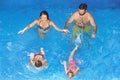 Happy family with children swimming with fun in blue pool Royalty Free Stock Photo