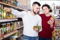 Happy family choosing purchasing canned food for week at supermarket Royalty Free Stock Photo