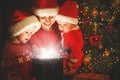 Happy family on Christmas Eve. mother and children discover a ma Royalty Free Stock Photo