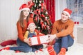 Happy family at Christmas eve sitting together near decorated tree Royalty Free Stock Photo