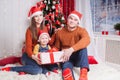 Happy family at Christmas eve sitting together near decorated tree Royalty Free Stock Photo