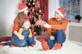 Happy family at Christmas eve sitting together near decorated tree Royalty Free Stock Photo