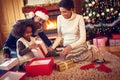 Happy family in Christmas morning opening present