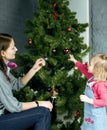 Happy family at Christmass, mother and daughter decorating green Royalty Free Stock Photo