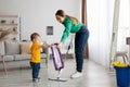 Happy family cleaning the room. Mother and toddler son doing the cleaning at home, kid boy helping mom washing floor Royalty Free Stock Photo