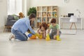 Happy family cleans room with gloves. Mother, son and daughter are cleaning house.