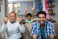 Happy family clenching fist while watching soccer match
