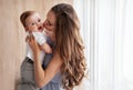 Happy family. Close up portrait of young attractive mother holding baby in her arms and gently kissing son Royalty Free Stock Photo