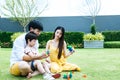 Happy family concept. Dad and mom teaching, playing toy with son together at garden around house with smiley faces. Cute boy is Royalty Free Stock Photo