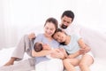 Happy family concept, father and daughter sit on bed excited looking new member in family, adorable newborn sleep on mother chest Royalty Free Stock Photo