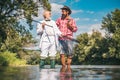 Happy family concept - father and son together. Fly angler on the river. Fishing in river. Man fishing. Generations men Royalty Free Stock Photo