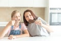 Mother with daughter in kitchen eating ice cream. Good relations of parent and child. Happy family concept Royalty Free Stock Photo