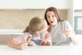 Mother with daughter in kitchen eating ice cream. Good relations of parent and child. Happy family concept Royalty Free Stock Photo