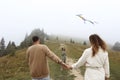 Happy family concept. parents and child are playing with a colorful kite. Young mother, father and their little cute Royalty Free Stock Photo