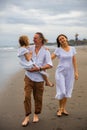 Happy family concept. Summer holidays. Family vacation in Asia. Mother  father and daughter walking barefoot along the beach. Royalty Free Stock Photo