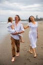 Happy family concept. Summer holidays. Family vacation in Asia. Mother, father and daughter walking barefoot along the beach. Royalty Free Stock Photo