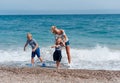 Happy family concept. attractive mother and little cute daughter and son having fun together on the beach Royalty Free Stock Photo